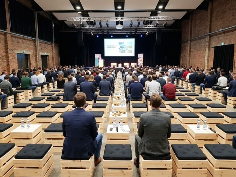 Holzhocker und Beistelltische mieten – Palettenhocker mit Sitzkissen bei einer Konferenz