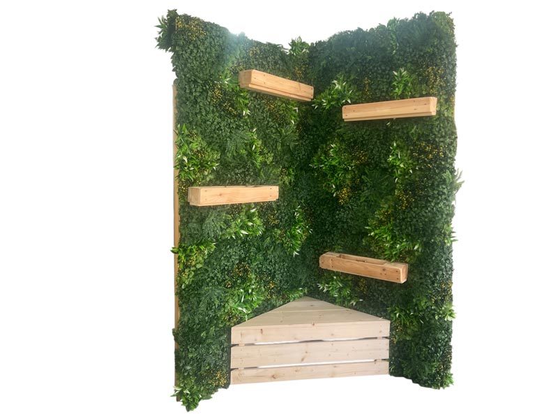 Pflanzenwand mieten Leipzig – freistehende Pflanzenwand-Ecke mit dichter Kunstpflanzen-Begrünung, vier Holz-Pflanzregalen und integrierter Sitzbank