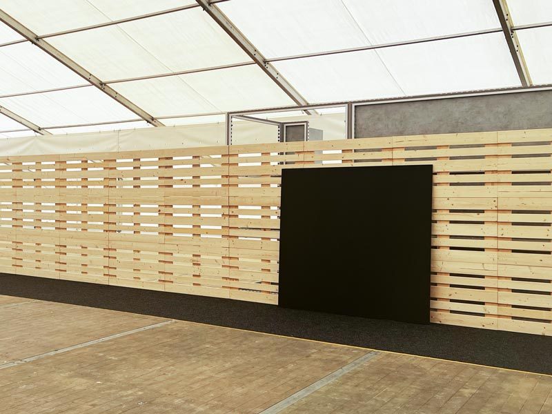 Tafelwand mieten Hamburg – lange Palettenwand mit integriertem Kreidetafel-Element in einem Eventzelt mit hellem Trapezdach