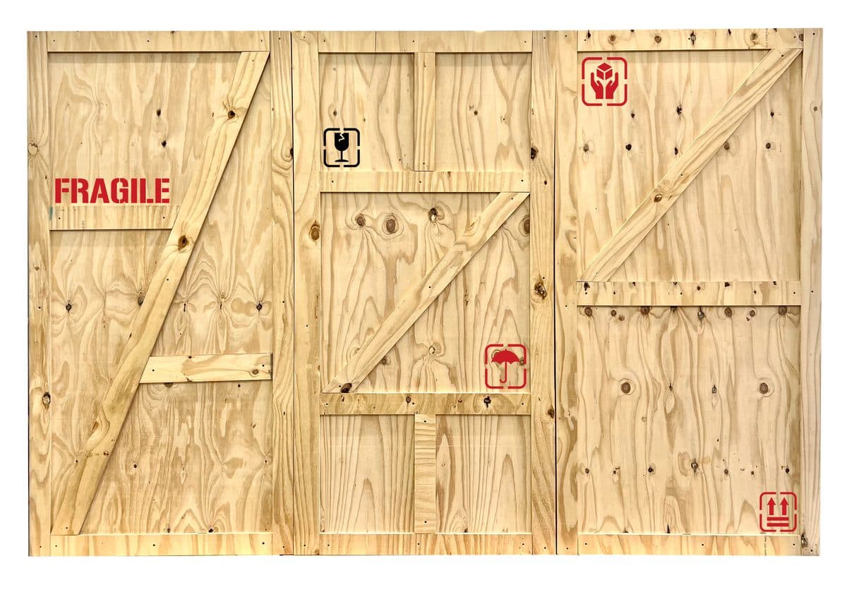 Messewand im Transportkisten-Stil zur Miete – Übersee-Look mit FRAGILE-Aufdruck und Z-Verstrebungen für Industrie- und Lifestyle-Messestände